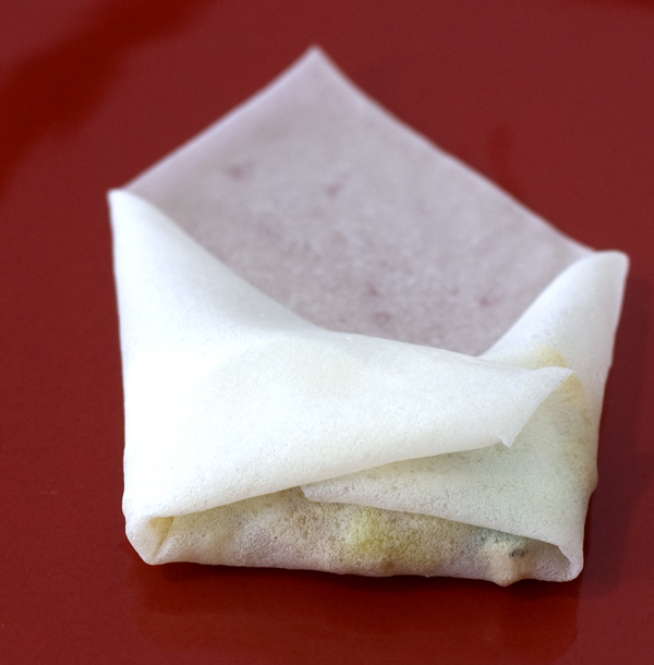 folding the spring roll lumpia in an envelope