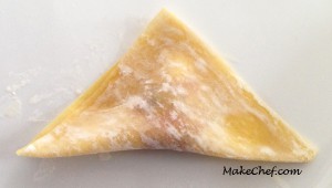 Folding dumpling into triangle.